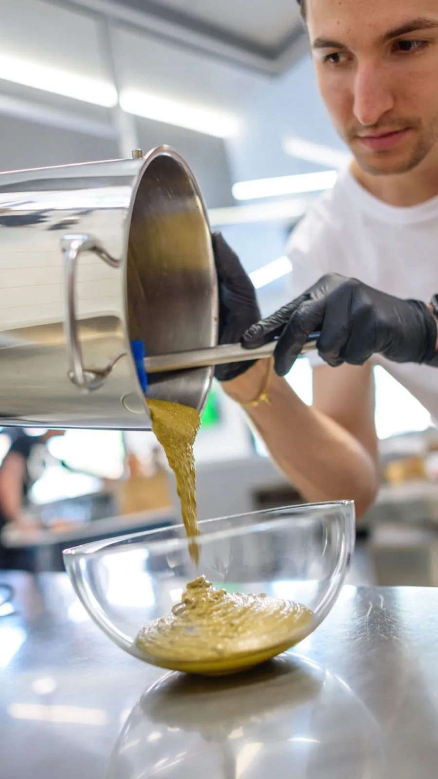 Gelatiere versa la pasta di pistacchio in laboratorio